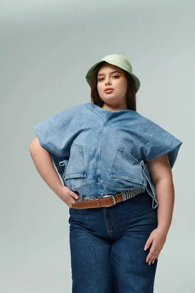 Beautiful woman showcases a trendy denim ensemble paired with a playful green bucket hat. — Stock Photo