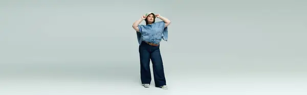 Una bella giovane donna plus size mostra la sua fiducia in un ensemble di denim alla moda. — Foto stock