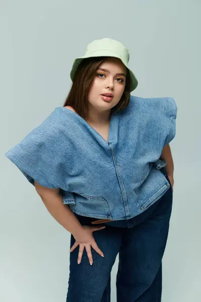 Una hermosa joven muestra su confianza en un atuendo de moda con un sombrero juguetón. - foto de stock