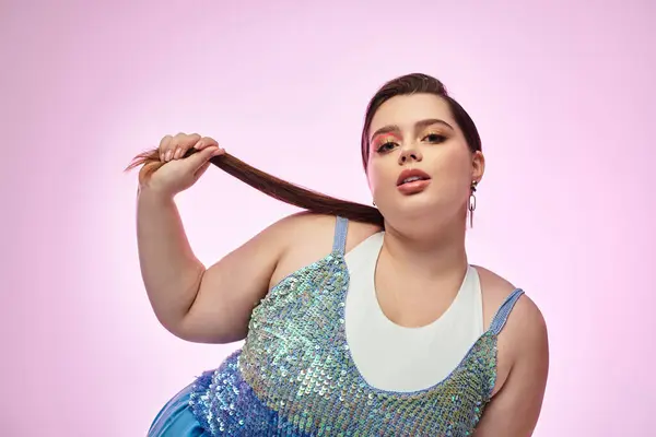 Una hermosa mujer de talla grande muestra su encanto, jugando con su cabello en un entorno vibrante. — Stock Photo