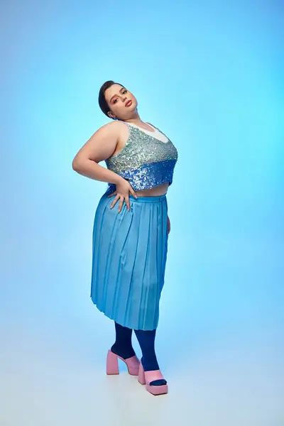 A young woman flaunts her style in a sparkly top and flowing skirt, posing elegantly. — Stock Photo