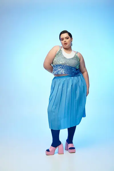 Confident plus size donna mette in mostra il suo vestito vibrante contro calmare sfondi blu. — Foto stock