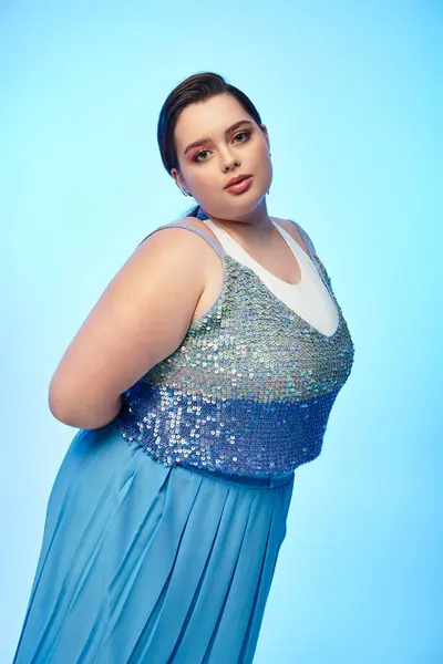 Donna più giovane con la figura plus size mostra fiducia in abito scintillante mentre colpisce una posa. — Foto stock