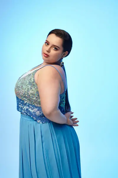 A young plus size woman poses gracefully in an elegant blue outfit, radiating confidence and charm. — Stock Photo