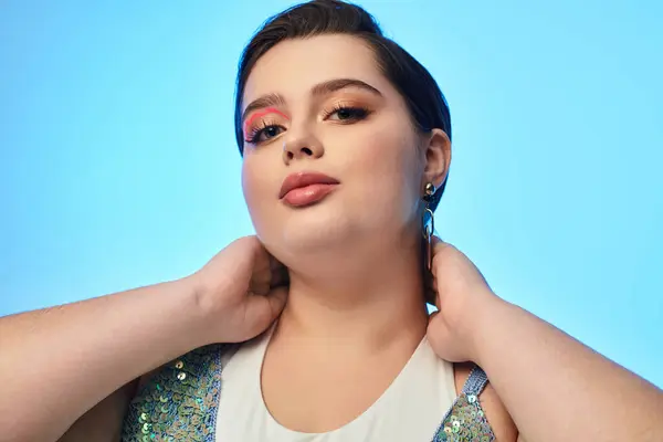 A beautiful young woman showcases her style and confidence with a playful pose and stunning makeup. — Stock Photo