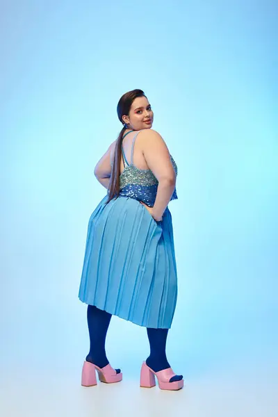 Giovane donna in abito blu posa con fiducia, in mostra la sua bellezza e stile. — Foto stock
