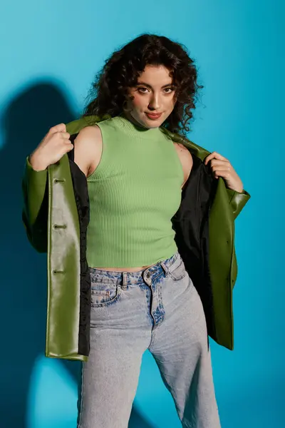 Una giovane donna mostra con sicurezza il suo vestito alla moda su uno sfondo blu sorprendente. — Foto stock