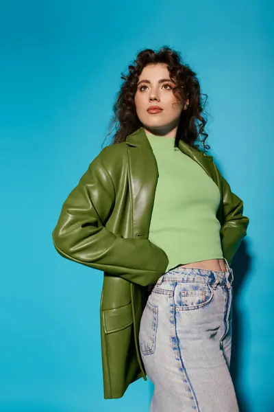 A fashionable young woman confidently poses in a vibrant green ensemble, radiating style. — Stock Photo