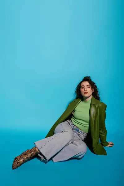 A stylish young woman sits confidently on the floor, wearing trendy outfits with a pop of color. — Stock Photo