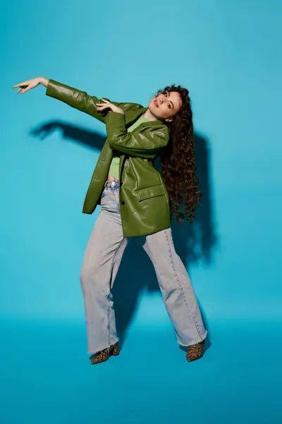 A trendy woman poses in a stylish green blazer and flared jeans, radiating confidence. — Stock Photo