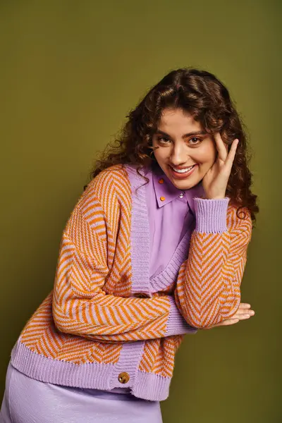 Young woman exudes confidence in colorful attire, posing cheerfully with a playful smile. — Stock Photo