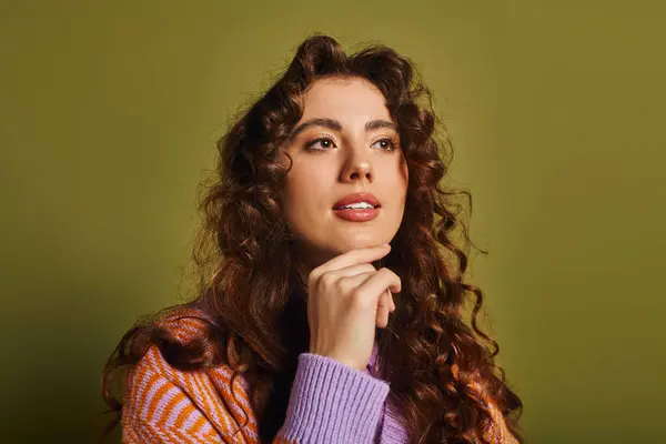 A young, fashionable woman with beautiful curls contemplates while sitting in cozy surroundings. — Stock Photo