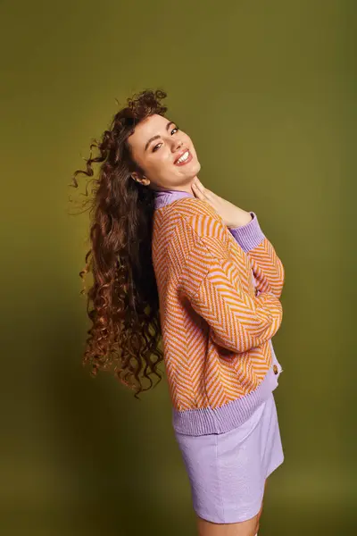A stylish young woman showcases her curly hair and trendy outfit, radiating joy. — Stock Photo