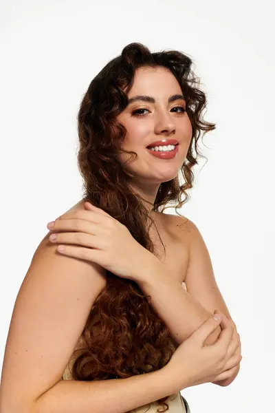 Elégante jeune femme pose avec confiance, soulignant son look élégant dans un studio lumineux. — Photo de stock