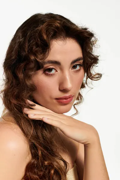 A beautiful young woman with flowing curls strikes an elegant pose, exuding confidence and style. — Stock Photo