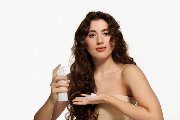 Confident young woman beautifully applies a skincare product while showcasing her stylish look. — Stock Photo