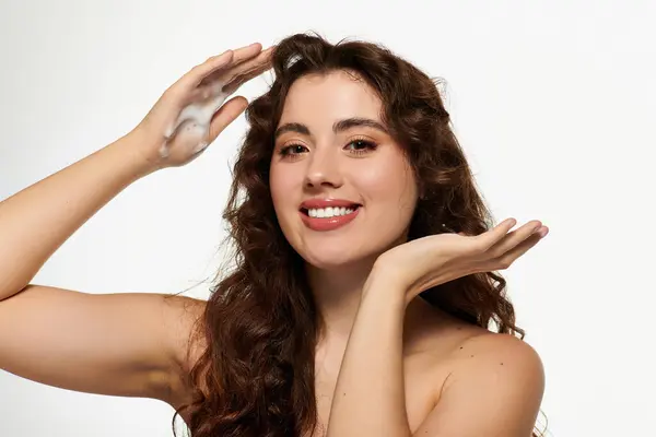 Young woman expresses happiness while demonstrating her skincare routine with foam on her hands. — Stock Photo