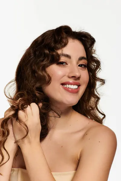A beautiful young woman with lovely curls happily poses, radiating confidence and style. — Stock Photo