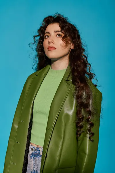 A young woman with curly hair flaunts her stylish green outfit, exuding confidence. — Stock Photo