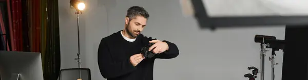 Опытный человек настраивает свою камеру во время подготовки к сессии в хорошо освещенной студии. — Stock Photo