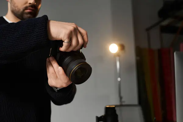 Un individuo dedicado prepara su cámara para una sesión de fotografía artística en un vibrante estudio. - foto de stock