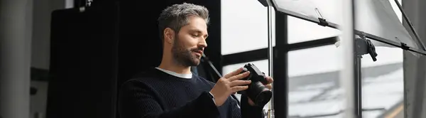Focused individual inspects camera gear while preparing for a creative project in a stylish studio — Stock Photo