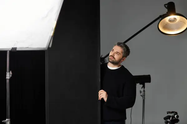 A man expertly operates studio gear, prepping for a professional shooting session. — Stock Photo