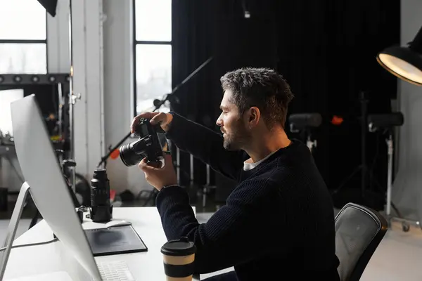 A man intently focuses on adjusting his camera settings in a contemporary studio environment. — Stock Photo