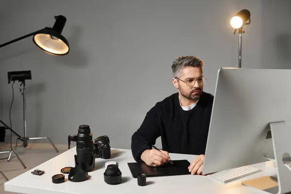 Edición individual enfocada digitalmente en medio del equipo de fotografía en un estudio. - foto de stock