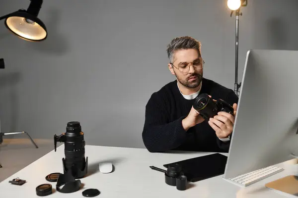 A skilled professional adjusts his camera gear in a contemporary workspace filled with equipment. — Stock Photo
