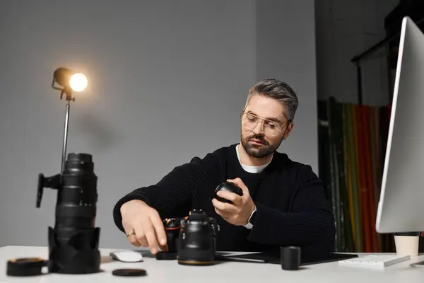 A skilled man diligently assembles camera equipment in a well lit studio, focusing on his craft. — Stock Photo