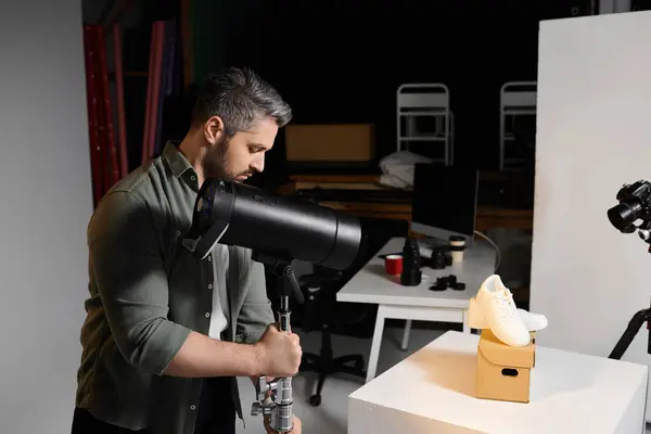 A man focuses on expertly lighting a stylish shoe on display in a contemporary workspace. — Stock Photo
