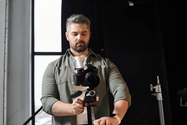 Кваліфікована людина створює фотоапарат для захоплення творчих моментів у яскравій студії. — стокове фото