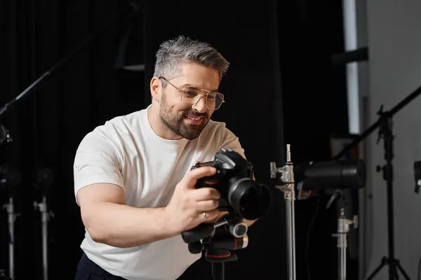 A skilled individual adjusts camera settings in a professional studio, showing focus and creativity. — Stock Photo