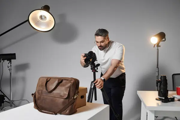 A skilled individual focuses on capturing an elegant product with careful attention in a studio. — Stock Photo