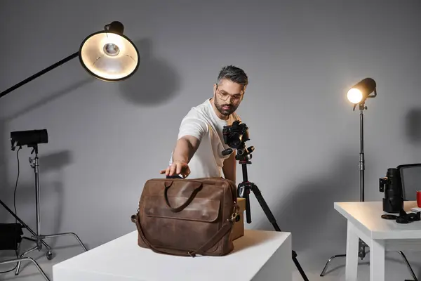 A skilled artist focuses on arranging his equipment in a well lit studio environment. — Stock Photo