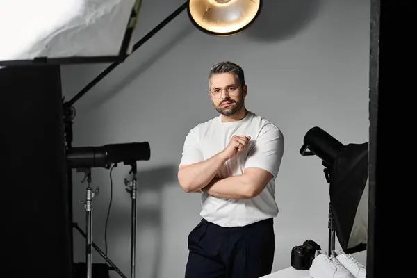 Un artista experto se centra en perfeccionar la iluminación en un estudio contemporáneo, mostrando dedicación. - foto de stock