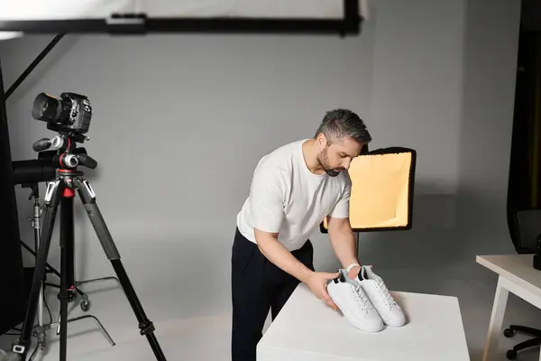 Un profesional organiza cuidadosamente el calzado en una pantalla ordenada, haciendo hincapié en la composición. - foto de stock