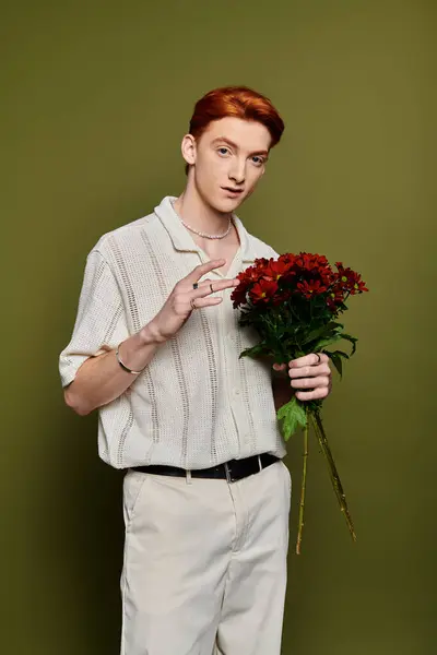 The handsome young man confidently holds a bouquet, exuding charm and sensitivity. — Stock Photo