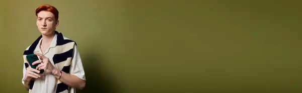 A young man displays various emotions while holding a phone against a green background. — Stock Photo