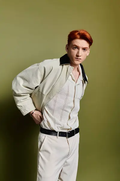 A handsome young man stands thoughtfully, dressed in light colors, showcasing his emotions. — Stock Photo