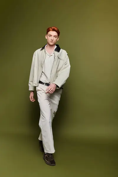 A handsome young man with striking red hair walks purposefully, reflecting deep emotion in his gaze. — Stock Photo