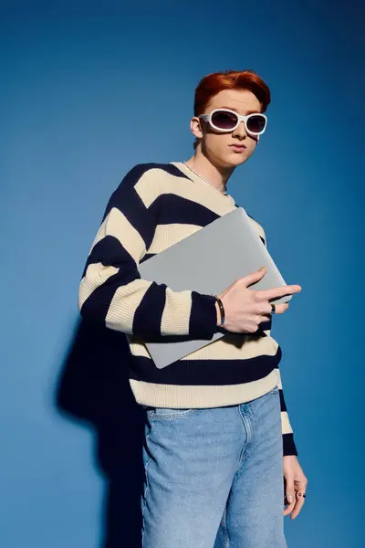 A stylish young man with a laptop expresses creativity through trendy fashion. — Stock Photo