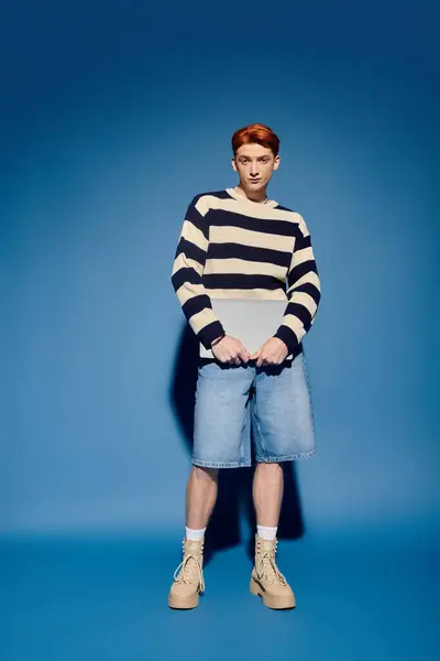 A young and handsome man stands confidently, showcasing his stylish outfit and emotional depth. — Stock Photo