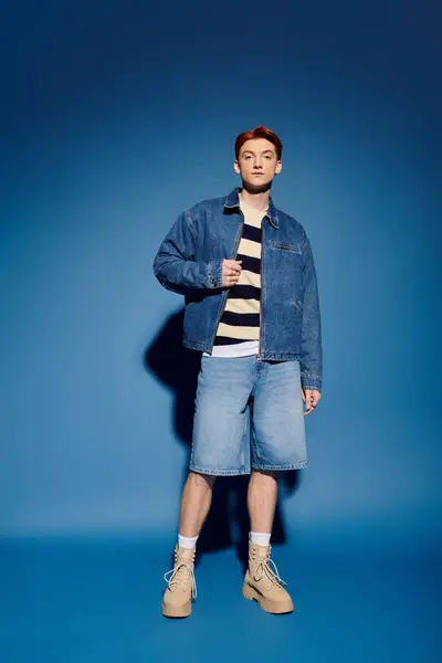 A young and handsome man stands confidently in trendy denim, showcasing his emotional depth. — Stock Photo