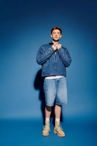 A young and handsome man stands confidently, showcasing a blend of emotion and fashion in denim. — Stock Photo