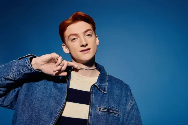 A young man expresses various emotions against a blue backdrop in stylish clothes. — Stock Photo