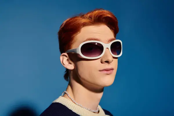 Handsome young man exuding emotion while wearing trendy sunglasses in a vibrant setting. — Stock Photo