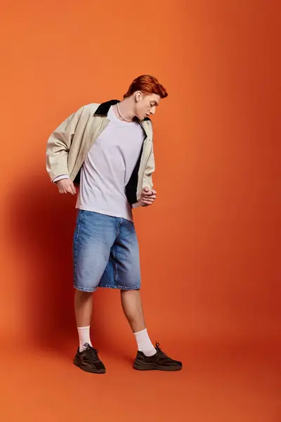 A young man expresses emotions while dressed casually, showcasing a stylish look. — Stock Photo
