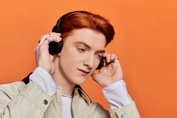 Emotional young man with handsome features immerses himself in music while wearing headphones. — Stock Photo